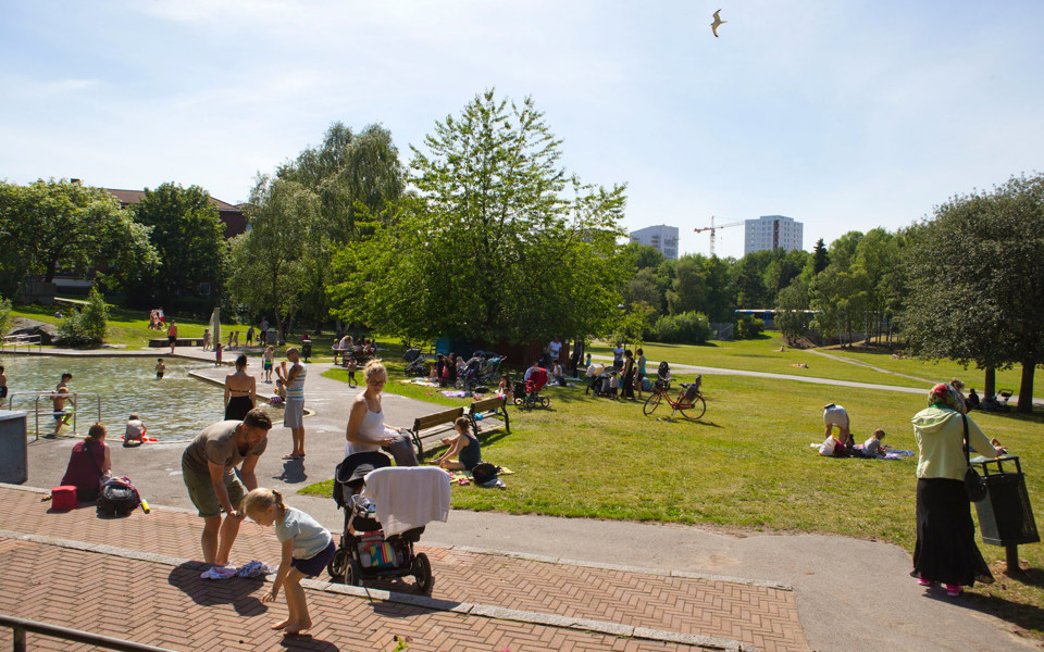 Ett grönområde med plaskdamm. Människor som umgås och badar, foto.