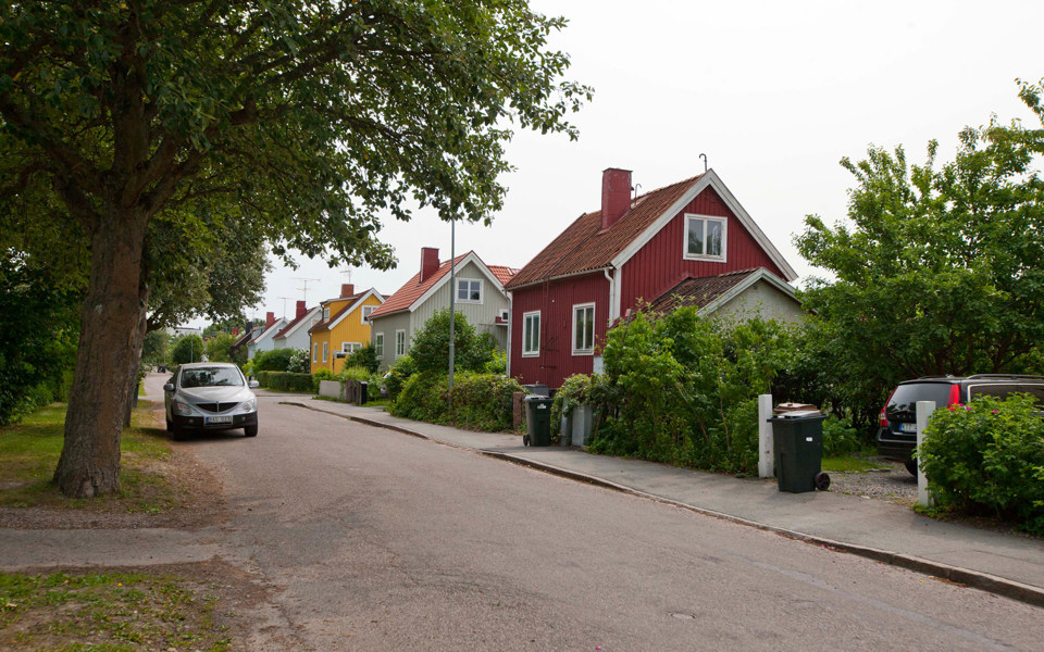 Villor i bostadsområde, gata, parkerad bil, grönska, fotografi.