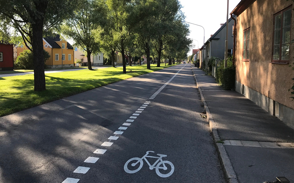 Gång- och cykelbana utmed bilväg i villaområde, foto.