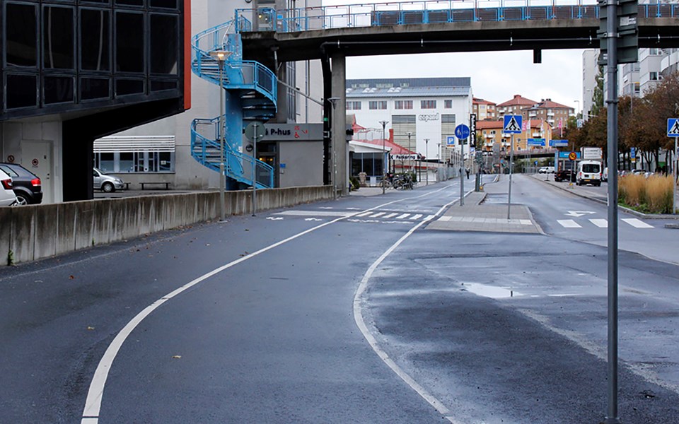 Gång- och cykelbana bredvid bilväg. Bro som går ovanför. Foto.