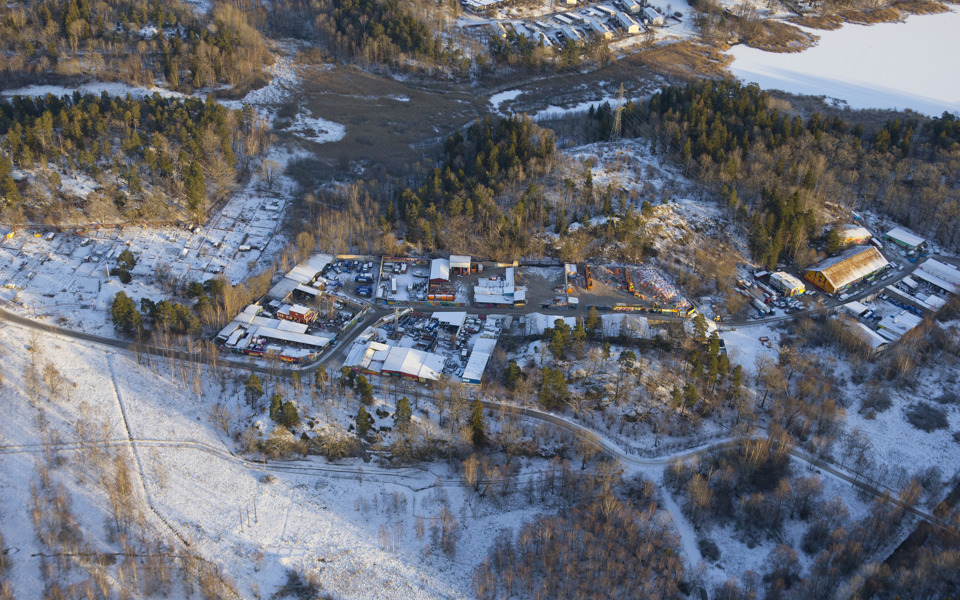 Flygvy över Snösätra industriområde med hus och skog runtom, foto.