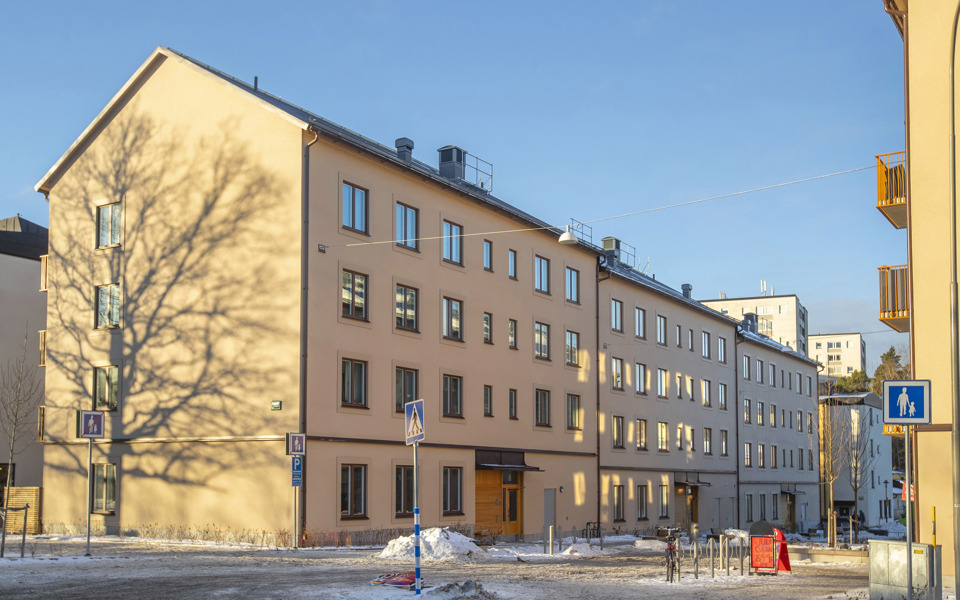 Ett lamellhus i fyra våningar med sadeltak, fotografi.