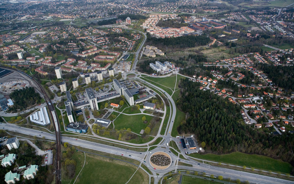 Flygfoto över samhälle. Vägar, hus och grönområden syns. 