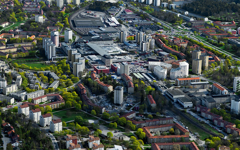 Små och stora bostadshus. Träd och gräsmattor. Foto.