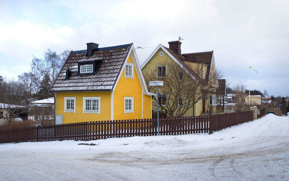 Vy över två villor i gatukorsning. Det är vinter och gatan är snöröjd. Foto.