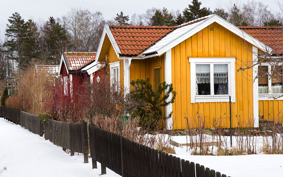 Trävillor med staket och trädgård. Foto.