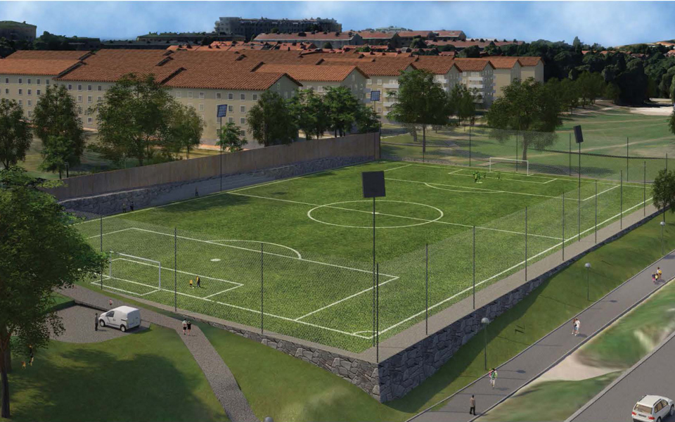 Fotbollsplan med stängsel runtom. Gångväg, bostadshus och träd som ligger i närheten. Illustration.