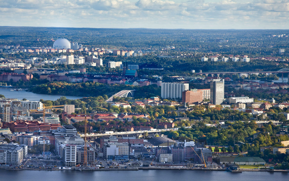 Bostadshus och grönområden omgivet av vatten, foto.