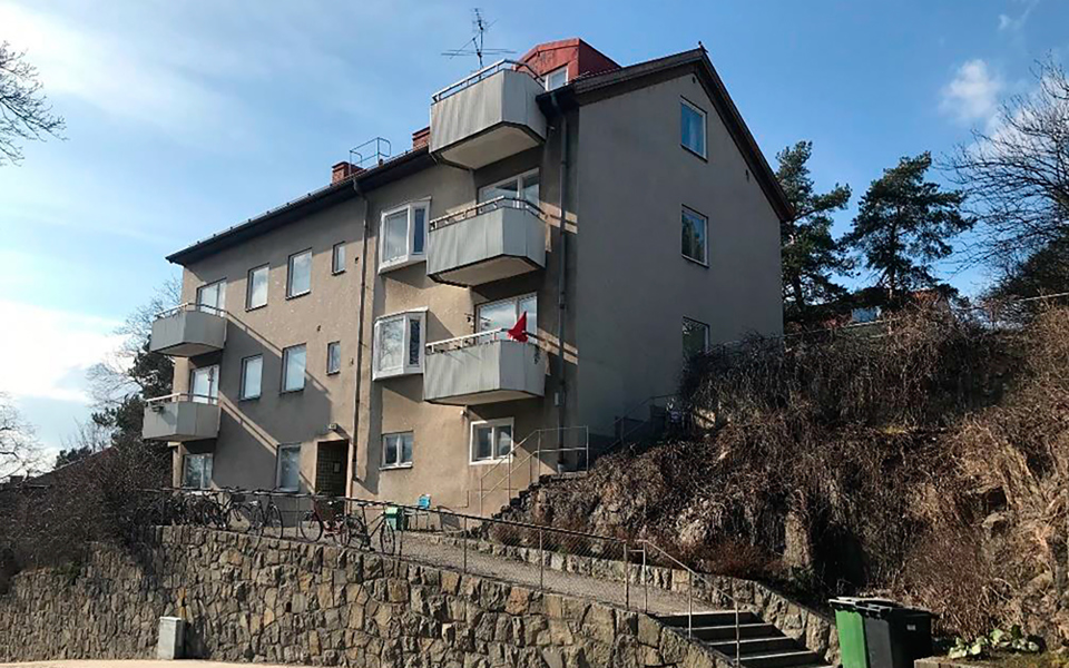 Bostadshus med 3 våningar och balkonger som ligger på höjd.  Foto.