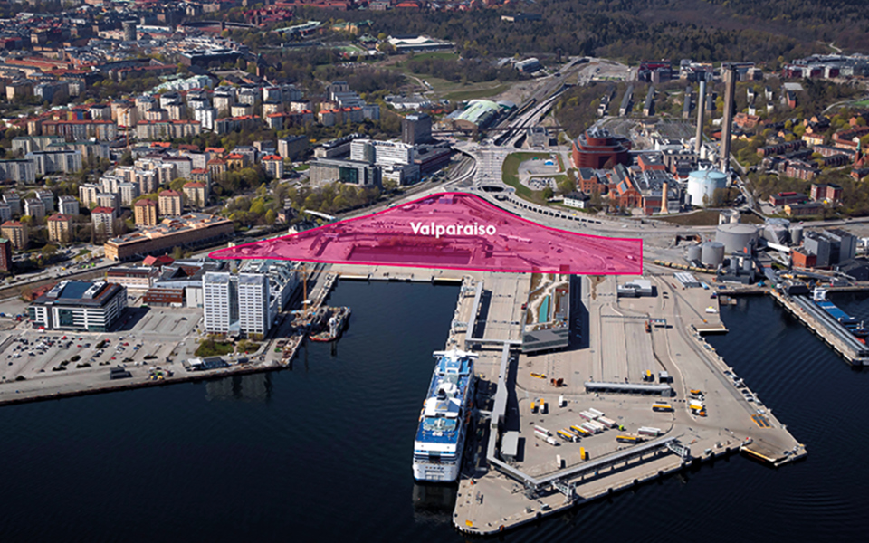 Hamn med båtar, vatten, kontors- och industribyggnader och bostadshus. Flygfoto.