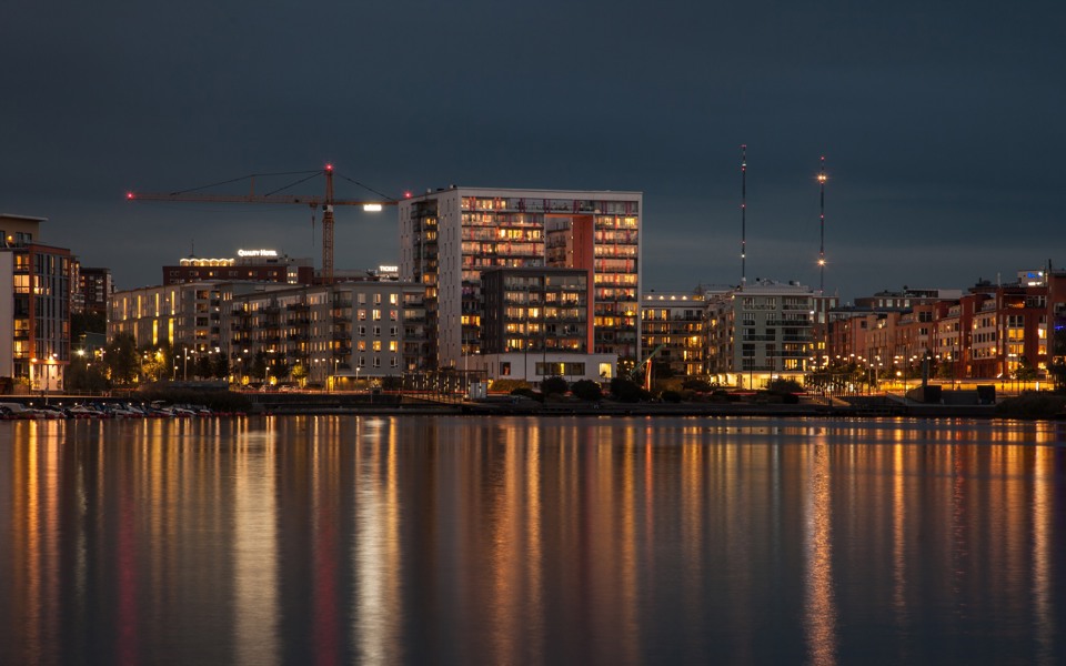 Kvällsvy över bostadshus i Hammarby sjöstad vid vattnet. Foto