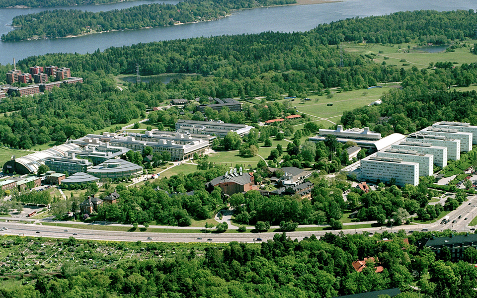 Flygvy över grönområden, vägar, vatten och hus, foto.