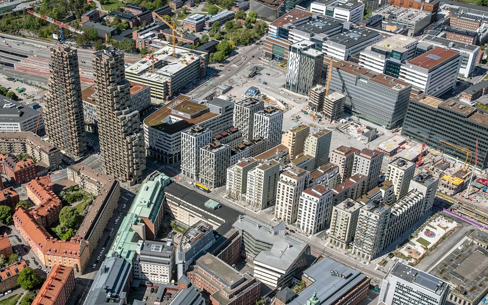 Flygvy över byggarbetsplats med flerbostadshus i stadsmiljö, fotografi.