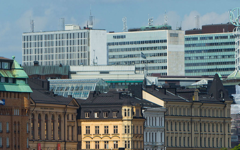 Flervåningshus. I bakgrunden syns Hötorgsskraporna och NK-skylten, foto. 