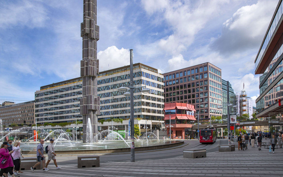 Foto över Sergels torg med statyn och fontänen vid rondellen.