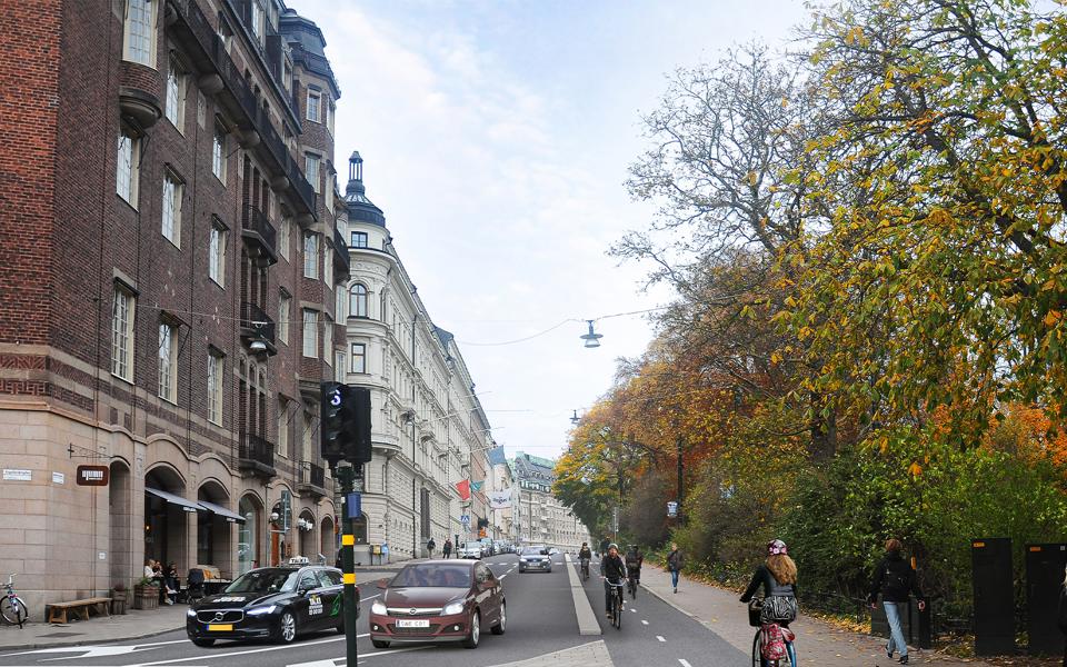 Cykelbana, gångbana och bilväg. Hus, träd, cyklar, bilar och människor i rörelse, visionsbild.