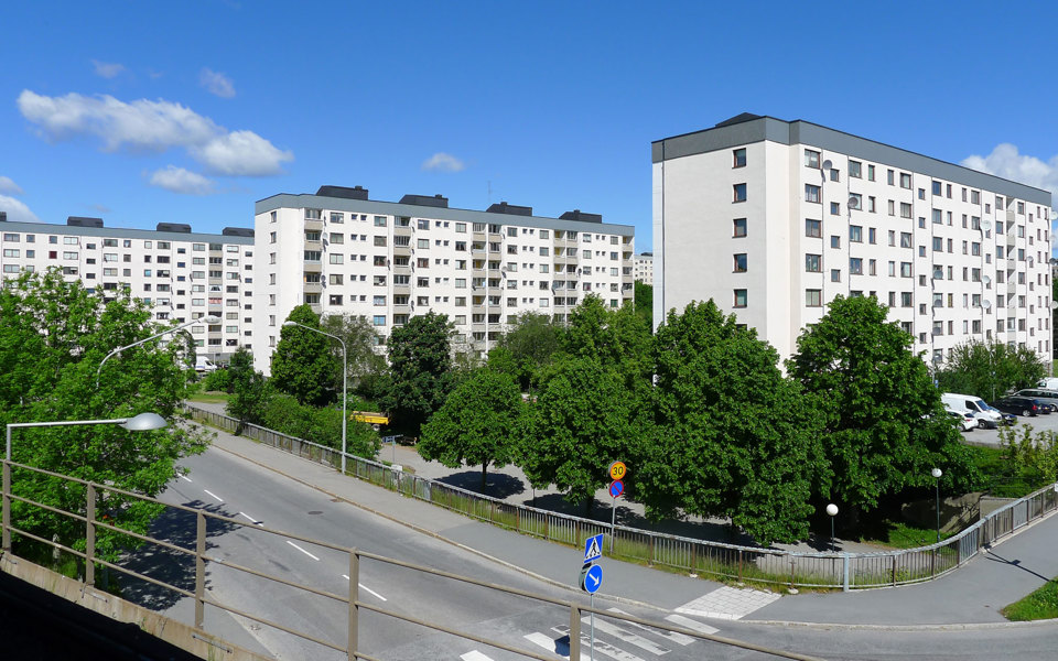 Vy över tre vita flerbostadshus på rad, fotografi.