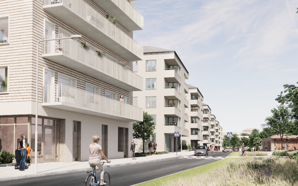 Bostadshus med balkonger placerade längs gata med cyklist. 