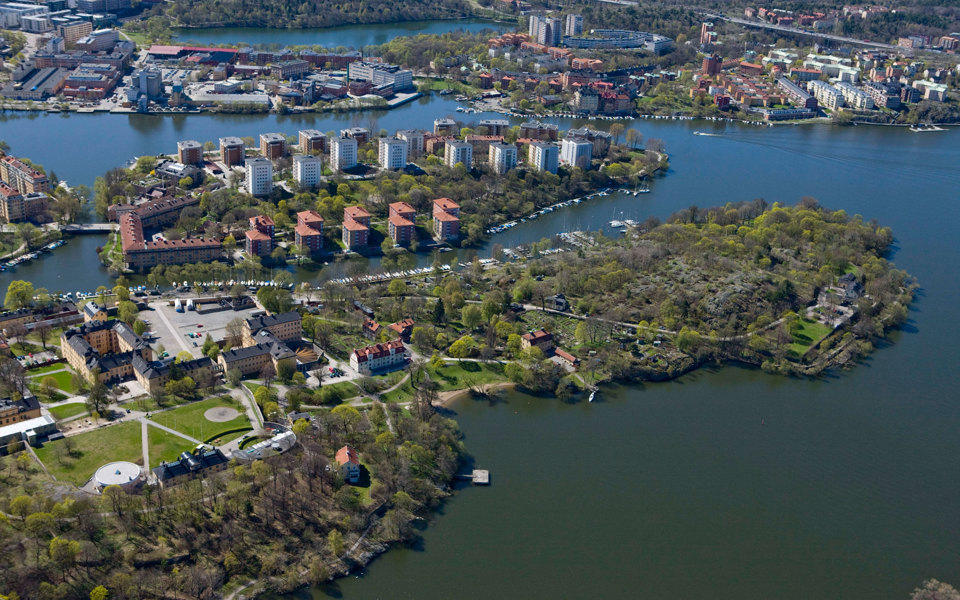 Flygvy. Grönområden, bostadsområden och vägar på öar omgärdade av vatten. Foto..