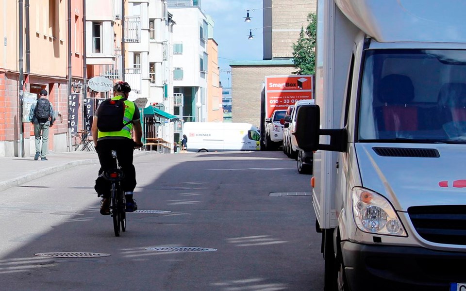 Cyklist cyklar förbi en vit skåpbil på Repslagargatan.