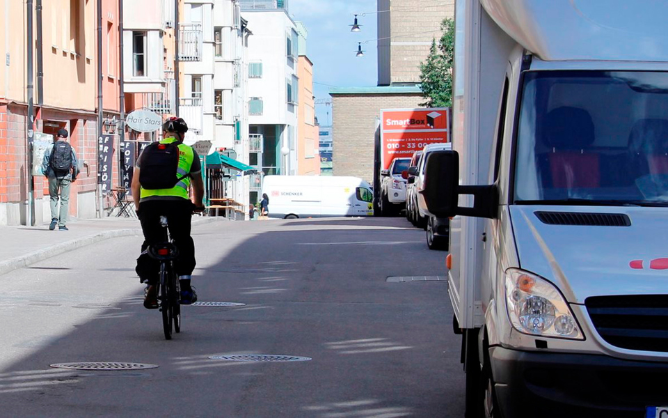 Cyklist cyklar förbi en vit skåpbil på Repslagargatan.