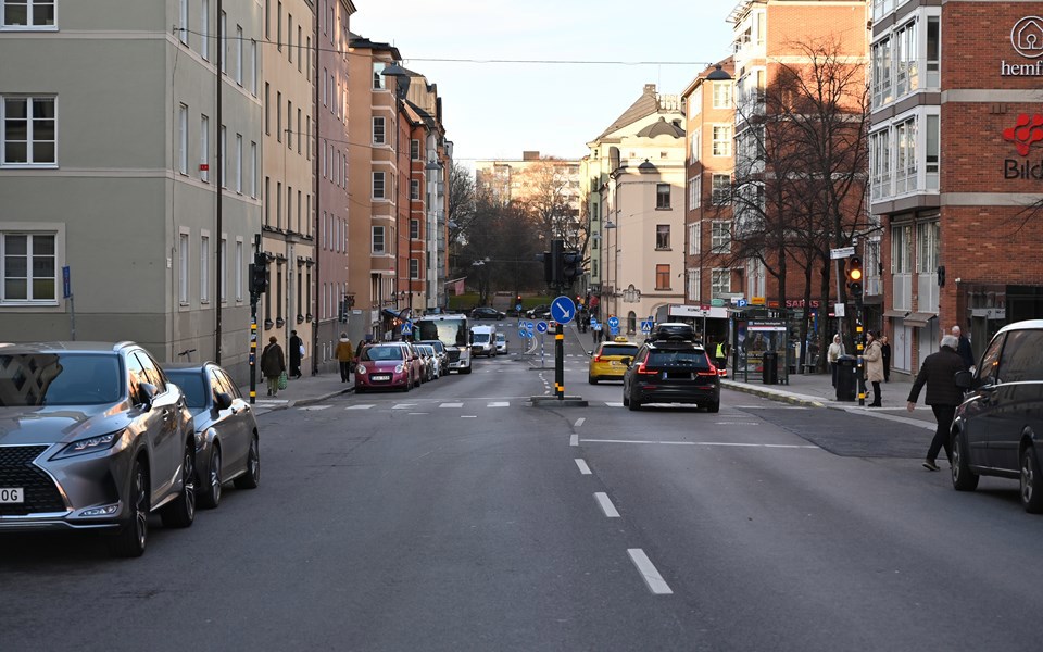 Foto över Rosenlundsgatan med biltrafik och omgiven av bostadshus och andra byggnader. 