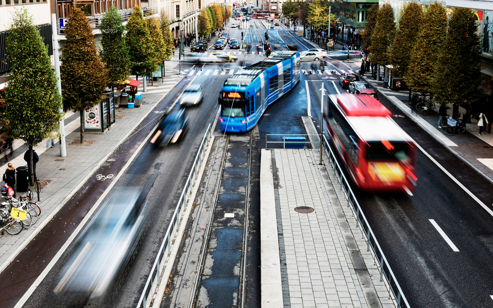 En spårvagn anländer till en hållplats samtidigt som en buss åker i motsatt riktning.