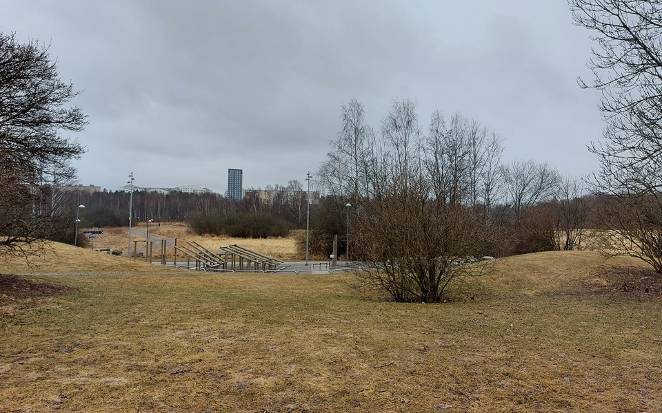 Vy mot utegym, omgivande natur, i bakgrunden skymtar höghus, fotografi.
